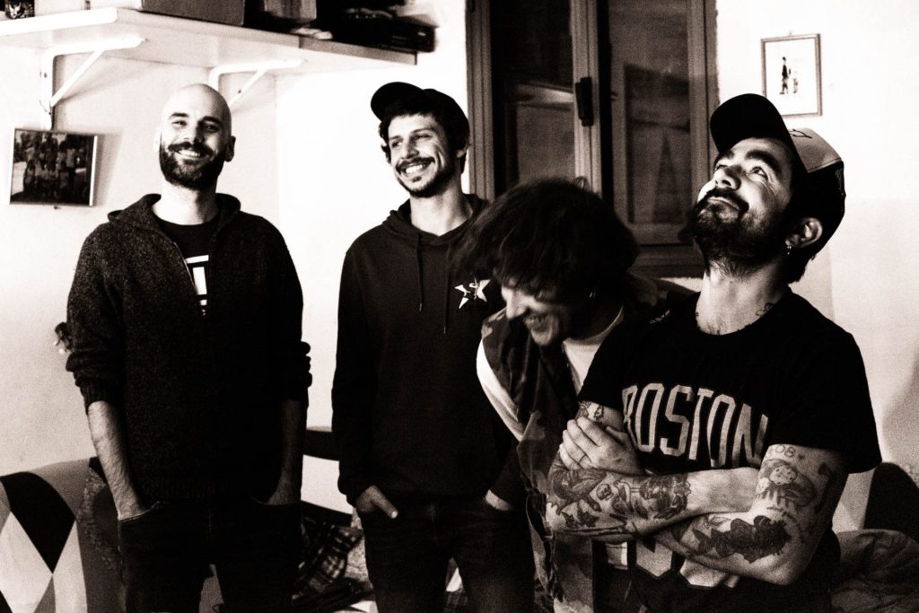 Foto in bianco e nero della band Hearts Apart. I quattro ragazzi ridono tra loro.
