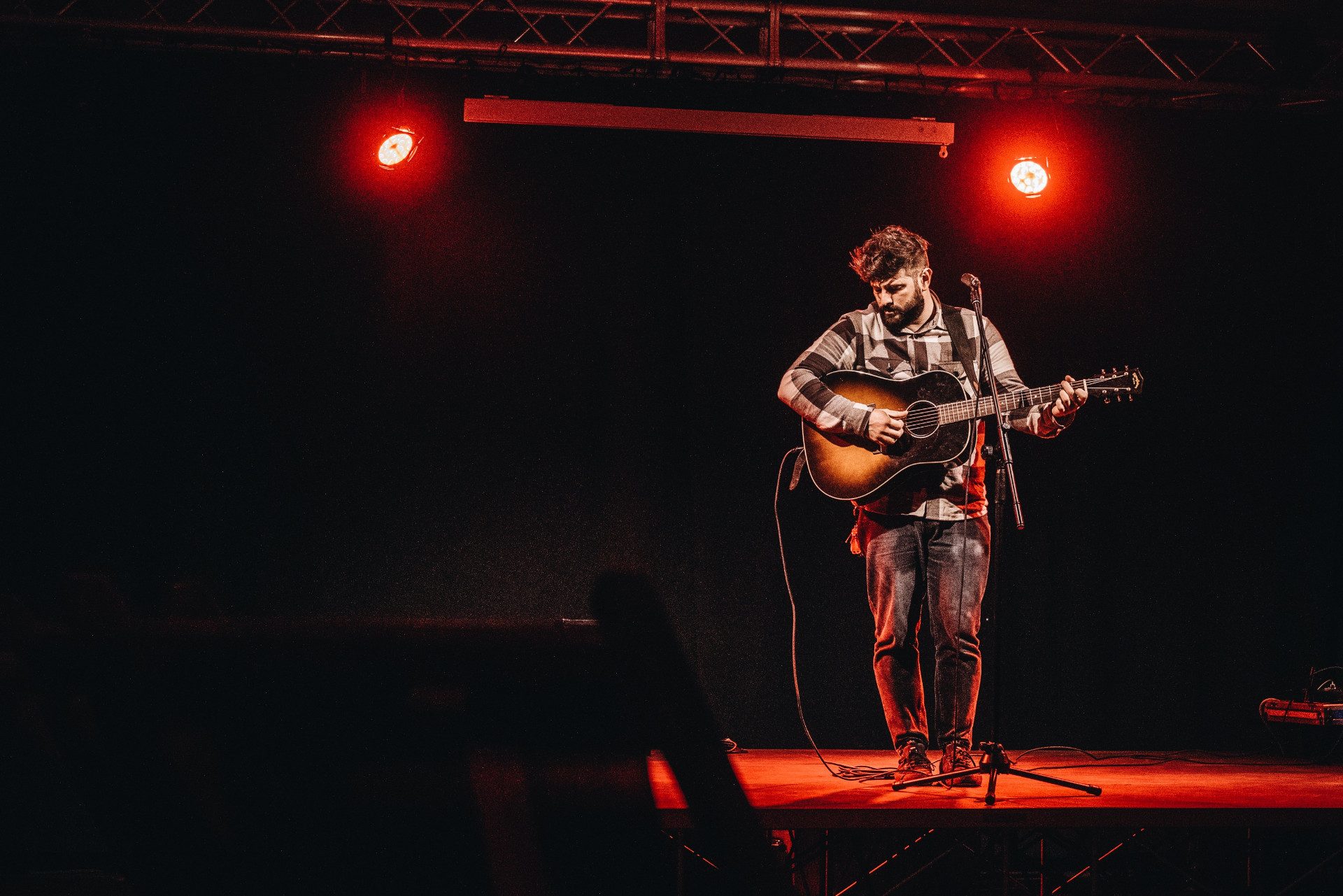 Candirù suona su un palco illuminato di rosso.