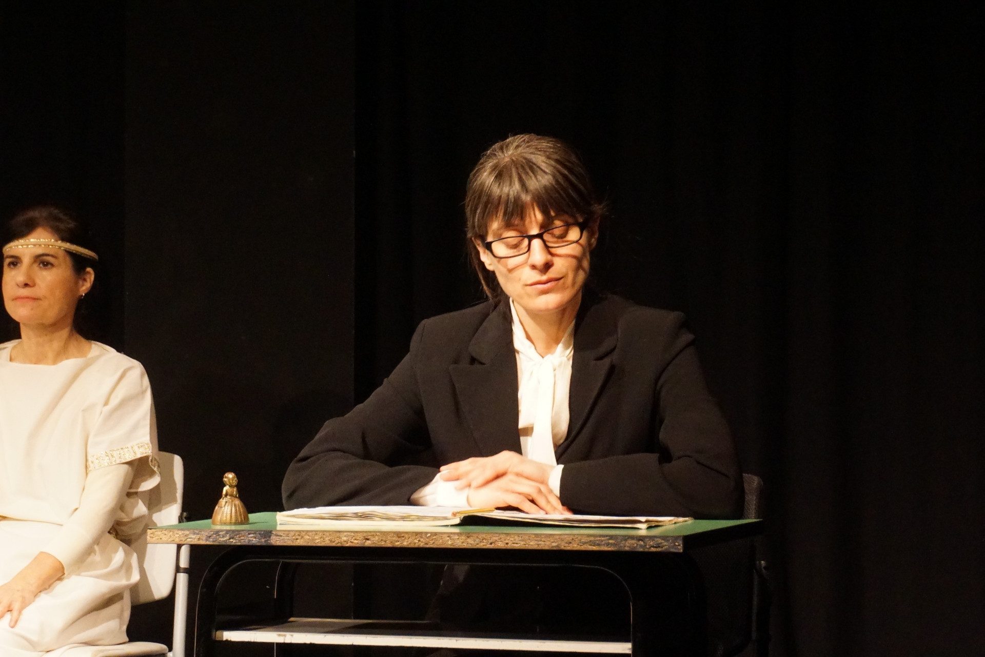 Un'attrice interpreta il ruolo di una docente severa che sta per interrogare la classe.