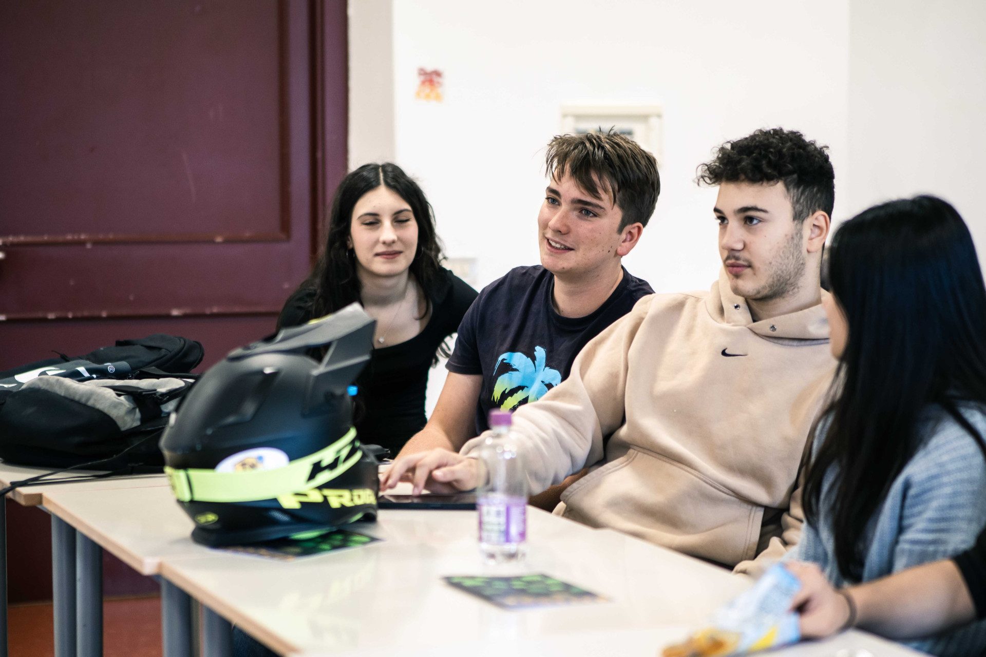 In un'aula scolastica, uno studente prende parola. I compagni lo ascoltano.