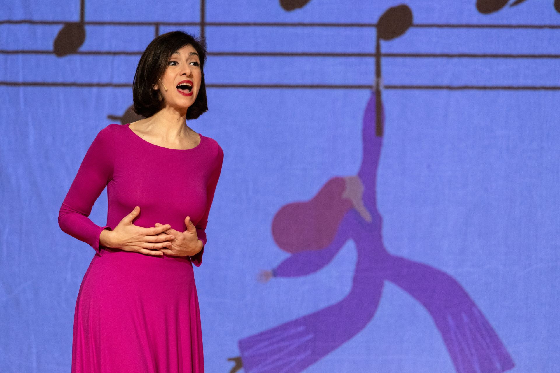 L'attrice Cinzia Spanò canta indossando un vestito fucsia