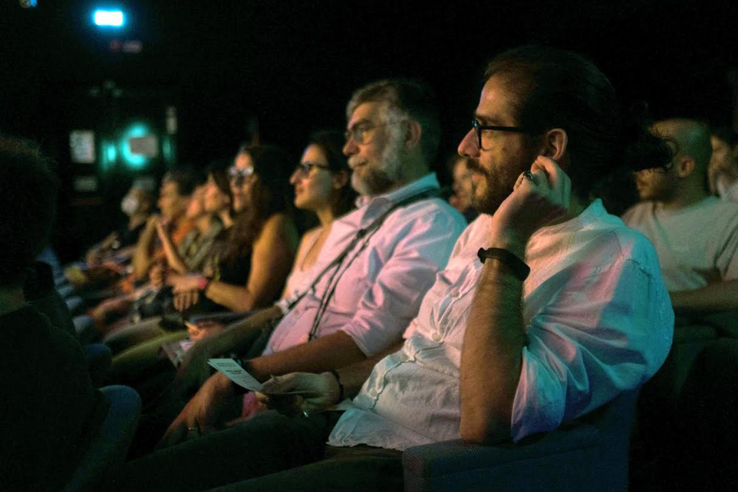 varie persone sedude in teatro che ascoltano un dialogo