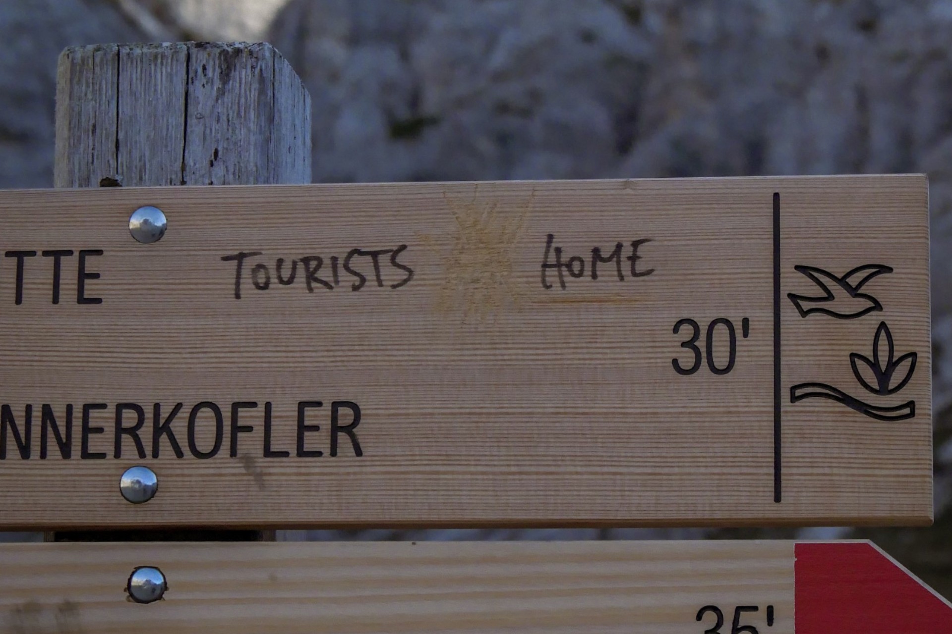 cartello di montagna con scritta "tourists home"